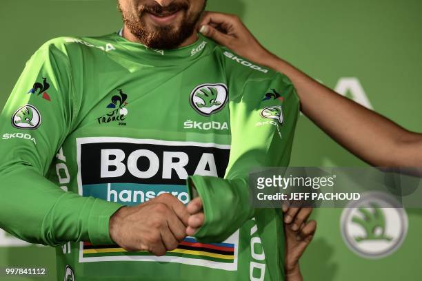 Slovakia's Peter Sagan puts on the best sprinter's green jersey on the podium after the seventh stage of the 105th edition of the Tour de France...