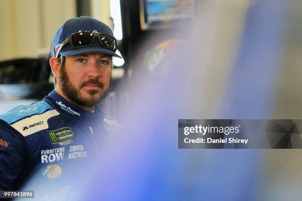 Martin Truex Jr., driver of the Auto-Owners Insurance Toyota, stands in the garage area during practice for the Monster Energy NASCAR Cup Series...