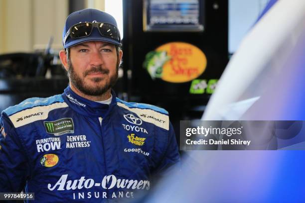 Martin Truex Jr., driver of the Auto-Owners Insurance Toyota, stands in the garage area during practice for the Monster Energy NASCAR Cup Series...