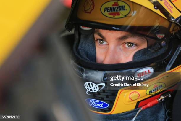 Joey Logano, driver of the Shell Pennzoil Ford, stands in the garage area during practice for the Monster Energy NASCAR Cup Series Quaker State 400...