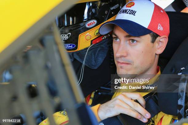 Joey Logano, driver of the Shell Pennzoil Ford, stands in the garage area during practice for the Monster Energy NASCAR Cup Series Quaker State 400...