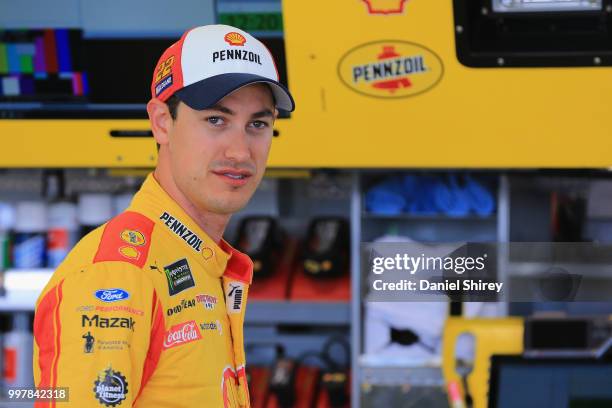 Joey Logano, driver of the Shell Pennzoil Ford, stands in the garage area during practice for the Monster Energy NASCAR Cup Series Quaker State 400...