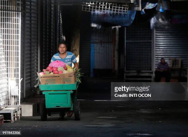 Man pushes a cart past closed stalls during a 24-hour nationwide general strike called by the opposition, at the "Oriental" market in Managua on July...