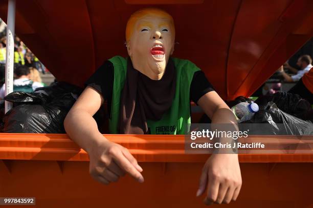 Protester in a Trump mask stands in a dumpster as they take part in a demonstration against President Trump's visit to the UK in Trafalgar Square on...