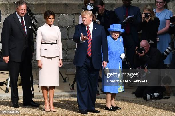 President Donald Trump gestures as he and US First Lady Melania Trump follow Britain's Queen Elizabeth II through the Quadrangle toward an entrance...