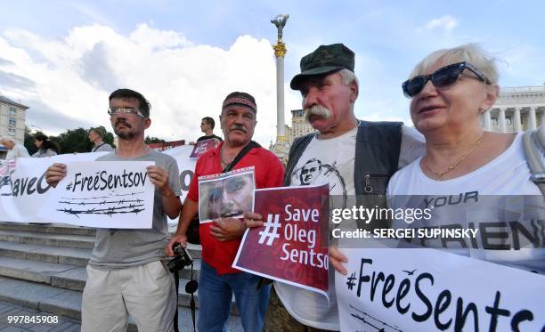 People hold placards during rally at Independence Square in Ukrainian capital of Kiev marking Oleg Sentsov birthday on July 13, 2018. - The mother of...