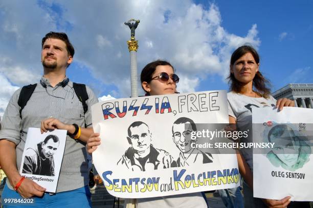 People hold placards during a rally at Independence Square in Ukrainian capital of Kiev marking Oleg Sentsov birthday on July 13, 2018. - The mother...