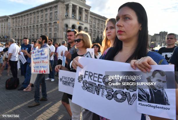 People hold placards during a rally at Independence Square in Ukrainian capital of Kiev marking Oleg Sentsov birthday on July 13, 2018. - The mother...