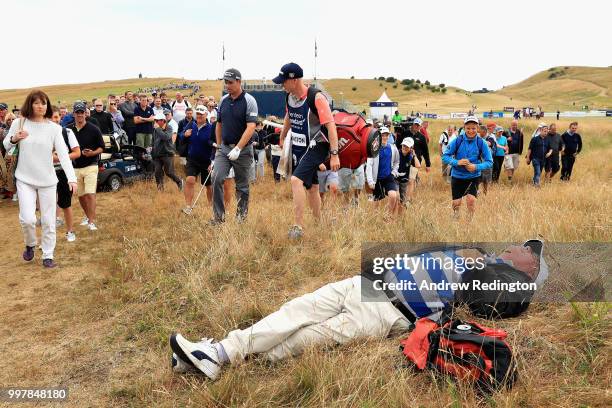 Spectator sleeps in the grass as Padraig Harrington of Ireland plays his second shot on hole eighteen during day two of the Aberdeen Standard...