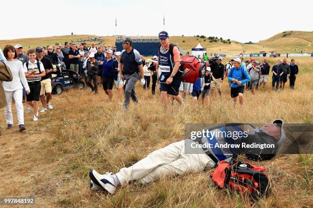 Spectator sleeps in the grass as Padraig Harrington of Ireland plays his second shot on hole eighteen during day two of the Aberdeen Standard...