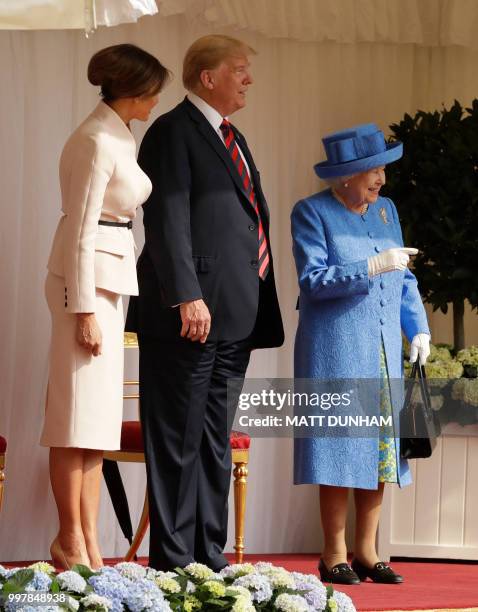 Britain's Queen Elizabeth II talks with US President Donald Trump and US First Lady Melania Trump on the dias in the Quadrangle during a welcome...