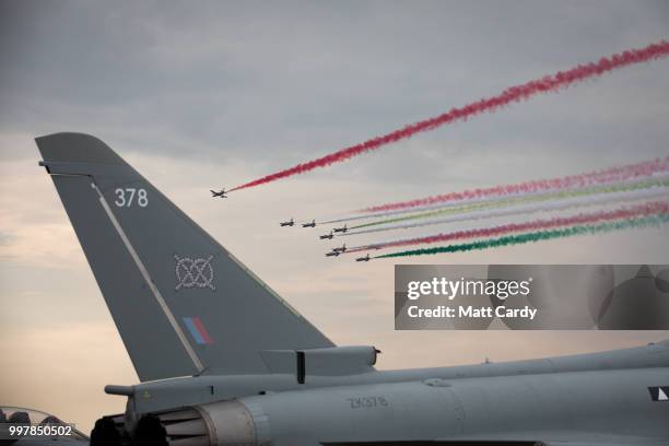 The Frecce Tricolori, Italian Air Force aerobatic display team fly above a Royal Air Force Eurofighter Typhoon that is being displayed at the Royal...