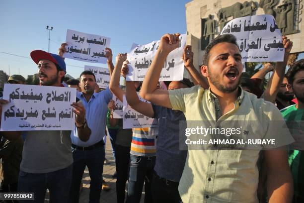 Iraqis shout slogans and raise placards during a protest against poor services, unemployment and corruption as they gather in the capital Baghdad's...