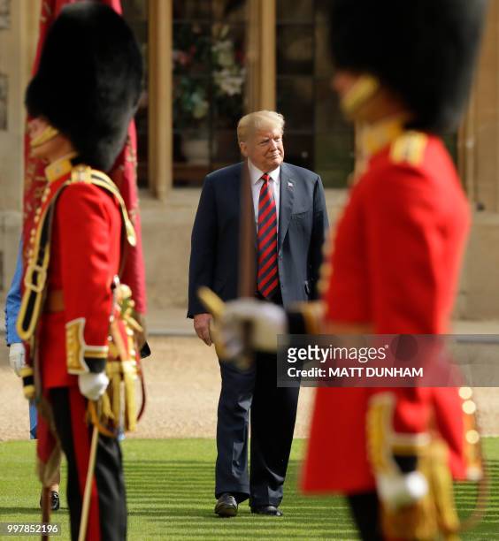 Britain's Queen Elizabeth II and US President Donald Trump walk to inspect the guard of honour formed of the Coldstream Guards during a welcome...