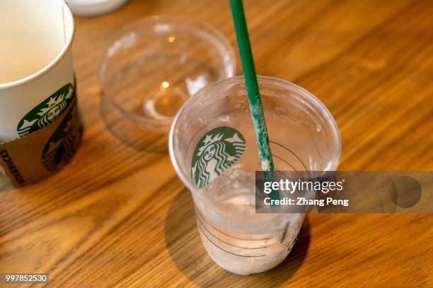Cup of Starbucks coffee with a plastic straw in it. Starbucks announced on July 9th that it would ban the use of plastic straws in its 28 thousand...