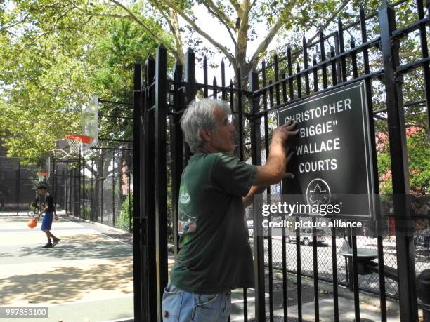 An employee of New York's park authority installs a plate that this basketball court is devoted to killed rapper Notorious BIG in New York, United...