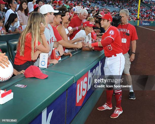 Fans in the stands on the third base side meet Los Angeles Angels of Anaheim infielder David Fletcher before the start off a game between the Seattle...