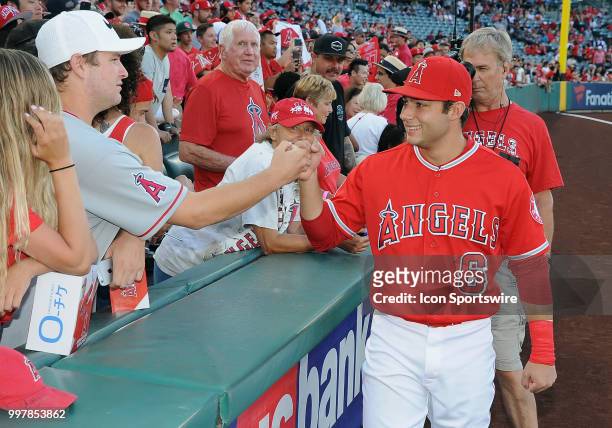 Fans in the stands on the third base side meet Los Angeles Angels of Anaheim infielder David Fletcher before the start off a game between the Seattle...