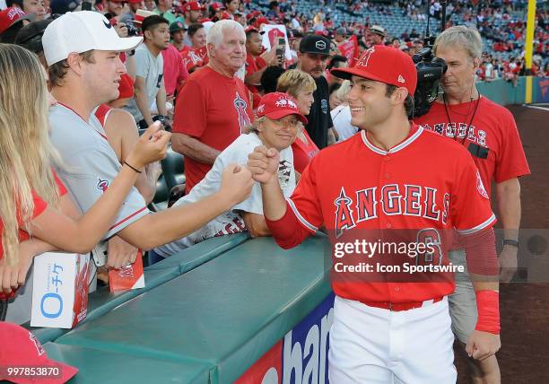 Fans in the stands on the third base side meet Los Angeles Angels of Anaheim infielder David Fletcher before the start off a game between the Seattle...