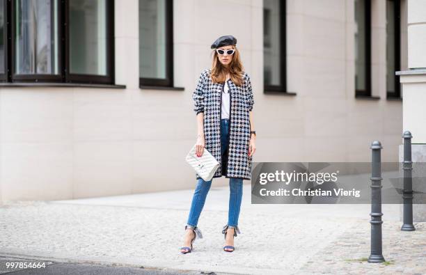 Alexandra Lapp is seen wearing an oversized checkered college jacket from Steffen Schraut, stirrup denim pants from Steffen Schraut, a white V-neck...