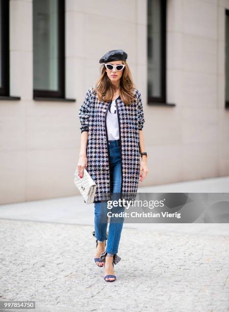 Alexandra Lapp is seen wearing an oversized checkered college jacket from Steffen Schraut, stirrup denim pants from Steffen Schraut, a white V-neck...