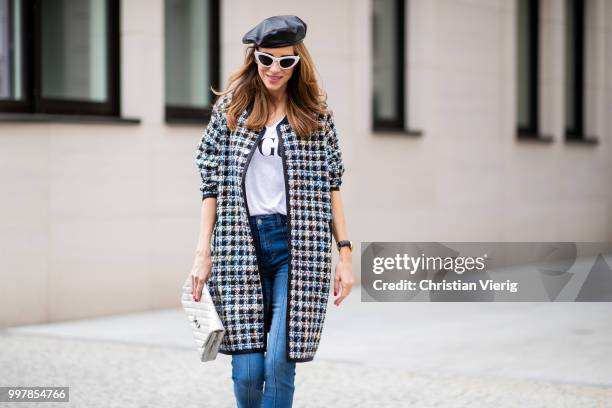 Alexandra Lapp is seen wearing an oversized checkered college jacket from Steffen Schraut, stirrup denim pants from Steffen Schraut, a white V-neck...