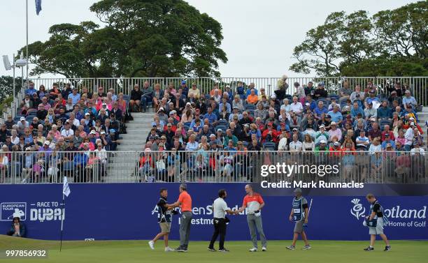 Alexander Levy of France and Martin Laird of Scotland and Ross Fisher of England finish their round at 18 green during the second day of the Aberdeen...