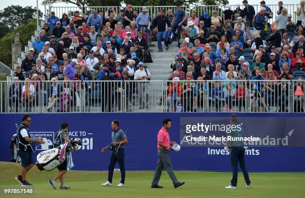 Justin Rose of England and Rickie Fowler of USA and Hideki Matsuyama of Japan finish their round at 18 green during the second day of the Aberdeen...