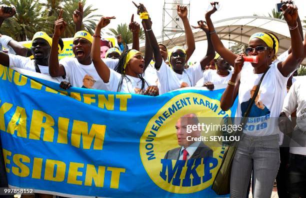 Senegalese opponents protest with a banner of the 'Mouvement Karim President' against the electoral system on July 13, 2018 in Dakar. - Karim Wade,...