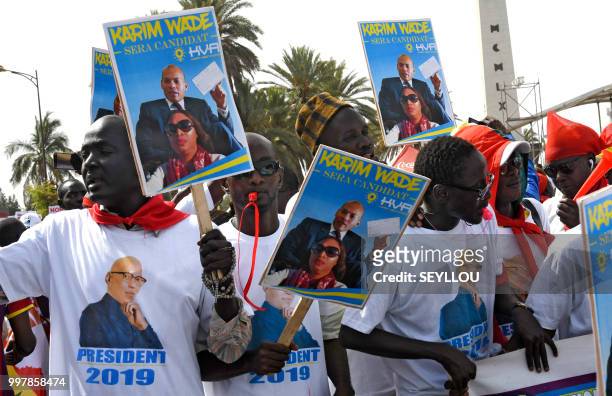 Senegalese opponents protest with placards reading 'Karim Wade will be president' against the electoral system on July 13, 2018 in Dakar. - Karim...