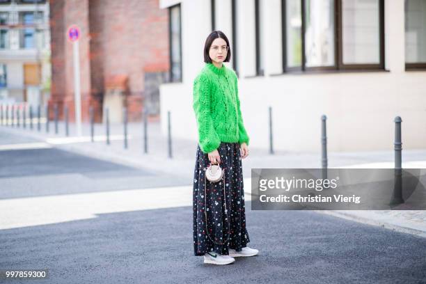 Maria Barteczko is seen wearing long flower printed dress Ganni, green oversized mohair sweater Ganni, white outburst sneaker Nike, mini metallic bag...