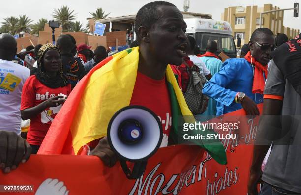 Demontrator reacts as Senegalese opponents protest against the electoral system on July 13, 2018 in Dakar. - Karim Wade, who served as a minister in...
