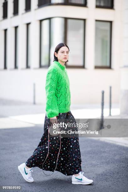 Maria Barteczko is seen wearing long flower printed dress Ganni, green oversized mohair sweater Ganni, white outburst sneaker Nike, mini metallic bag...