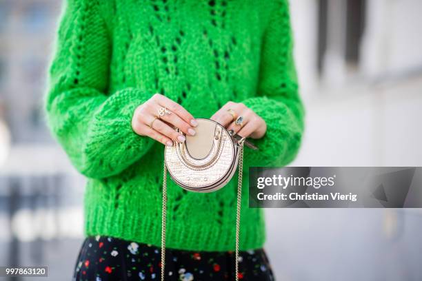 Maria Barteczko is seen wearing long flower printed dress Ganni, green oversized mohair sweater Ganni, white outburst sneaker Nike, mini metallic bag...