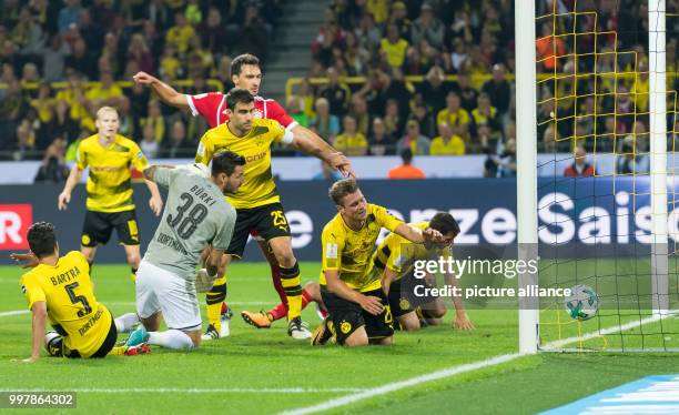 The ball rolling past Dortmund's Marc Bartra, goalkeeper Roman Burki, Sokratis, Lukasz Piszczek, Gonzalo Castro and Bayern Munich's Mats Hummels and...