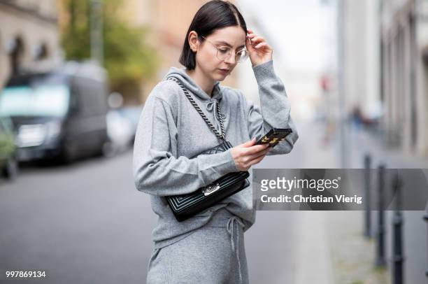 Maria Barteczko is seen wearing sporty grey cashmere hoodie Villao, grey cashmere wide leg pants Villao, Louis Vuitton iphone case, logo sneaker...
