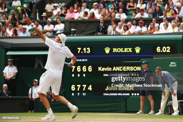 John Isner of The United States serves against Kevin Anderson of South Africa in front of the scoreboard during their Men's Singles semi-final match...