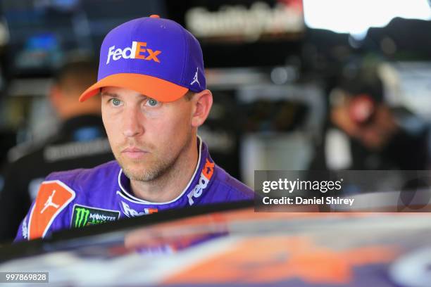 Denny Hamlin, driver of the FedEx Office Toyota, stands in the garage area during practice for the Monster Energy NASCAR Cup Series Quaker State 400...