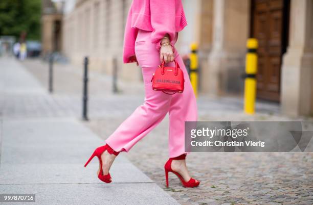 Maria Barteczko is seen wearing a pink oversized cashmere sweater Celine, pink cropped wool trousers Celine, red plateau sandals Steve madden, red...