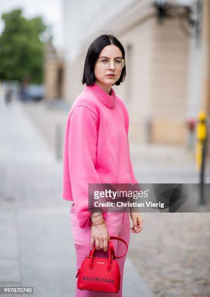 Maria Barteczko is seen wearing a pink oversized cashmere sweater Celine, pink cropped wool trousers Celine, red plateau sandals Steve madden, red...