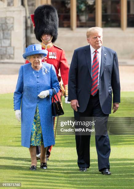 President Donald Trump and Britain's Queen Elizabeth II inspect a Guard of Honour, formed of the Coldstream Guards at Windsor Castle on July 13, 2018...