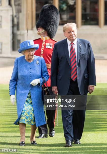 President Donald Trump and Britain's Queen Elizabeth II inspect a Guard of Honour, formed of the Coldstream Guards at Windsor Castle on July 13, 2018...