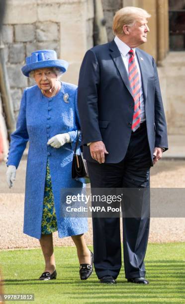 President Donald Trump and Britain's Queen Elizabeth II inspect a Guard of Honour, formed of the Coldstream Guards at Windsor Castle on July 13, 2018...