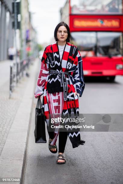 Maria Barteczko is seen wearing a patchwork knit coat Stella McCartney, black skinny jeans Acne Studios, black studded sandals Givenchy, black logo...