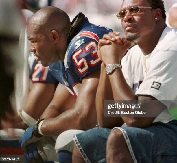 Injured New England Patriots player Willie McGinest, right, watches the game from the bench with teammate Chris Slade. The New England Patriots visit...