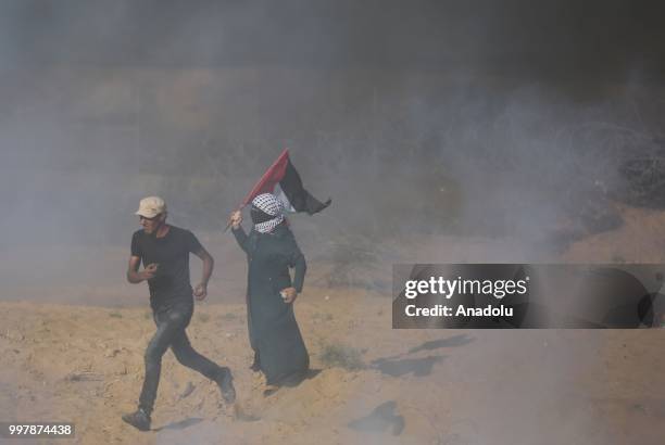 Israeli forces use tear gas to disperse Palestinian demonstrators taking part in the "Great March of Return" demonstration with ''Fidelity to Khan...