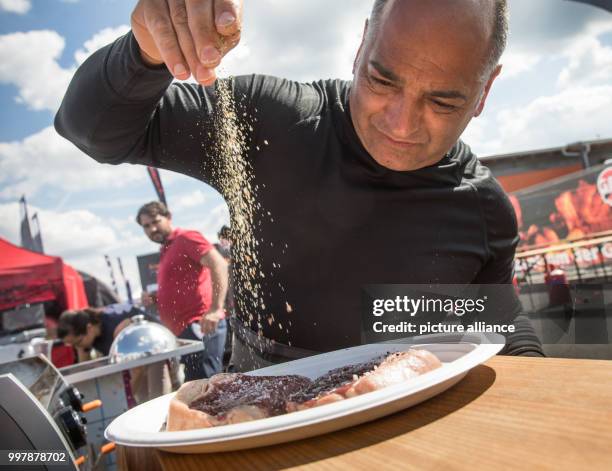 Scottish chef Chris Sandford adds salt to a steak in order to grill it a la plancha style during the German Grill Championship in Fulda, Germany, 06...