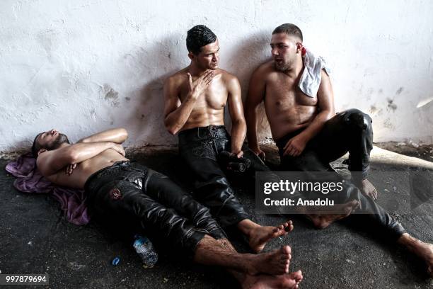 Wrestlers rest after competing on the first day of the 657th annual Kirkpinar Oil Wrestling Festival in Sarayici near Edirne, Turkey on July 13, 2018.