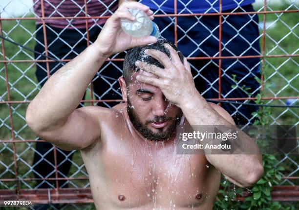 Young wrestler cools off with water after competing on the first day of the 657th annual Kirkpinar Oil Wrestling Festival in Sarayici near Edirne,...