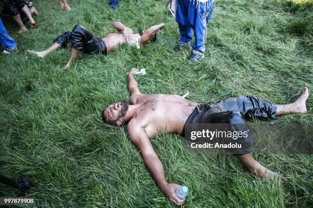 Wrestlers rest after competing on the first day of the 657th annual Kirkpinar Oil Wrestling Festival in Sarayici near Edirne, Turkey on July 13, 2018.